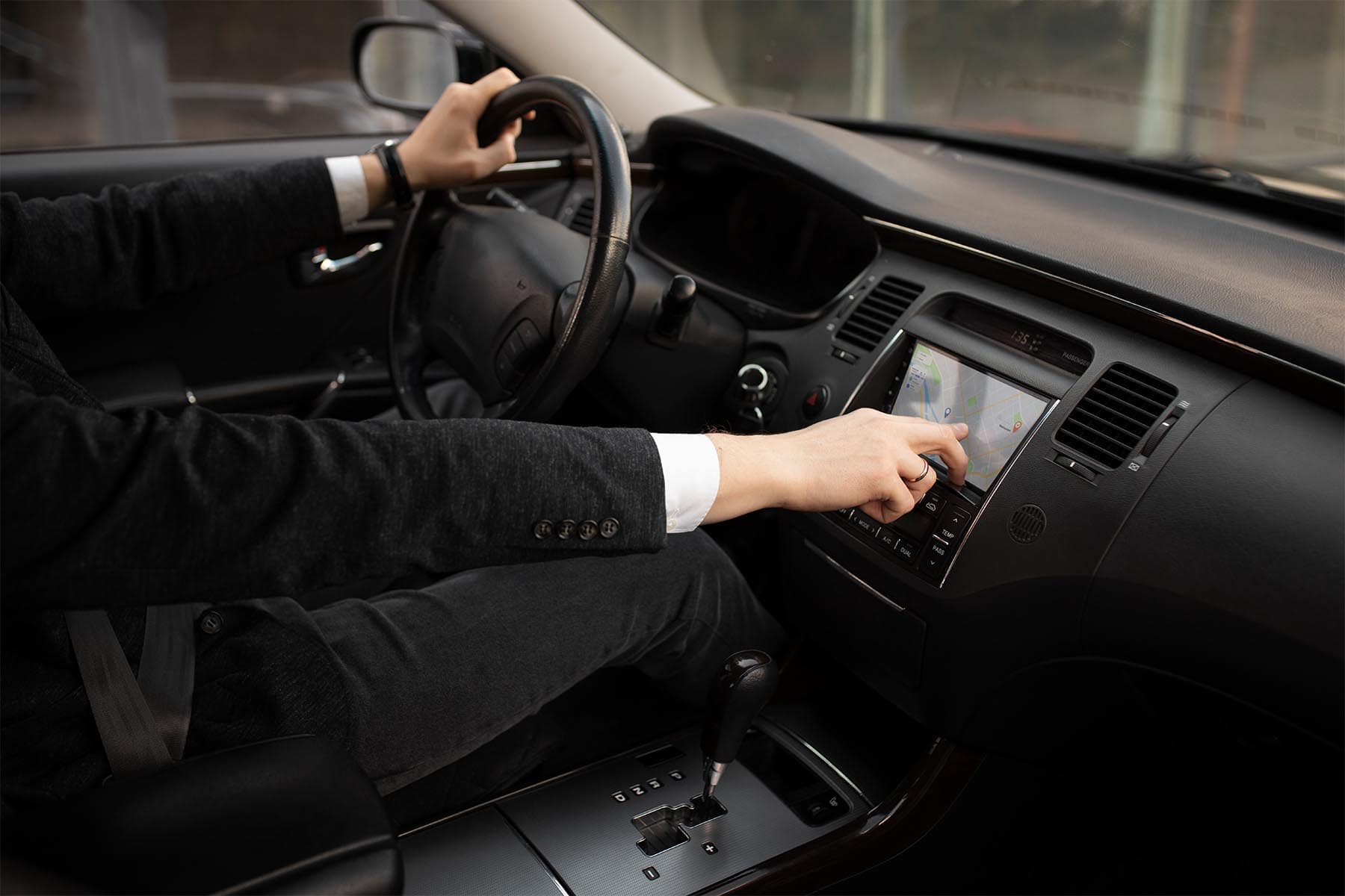 Conducteur qui regarde son gps dans son véhicule noble.